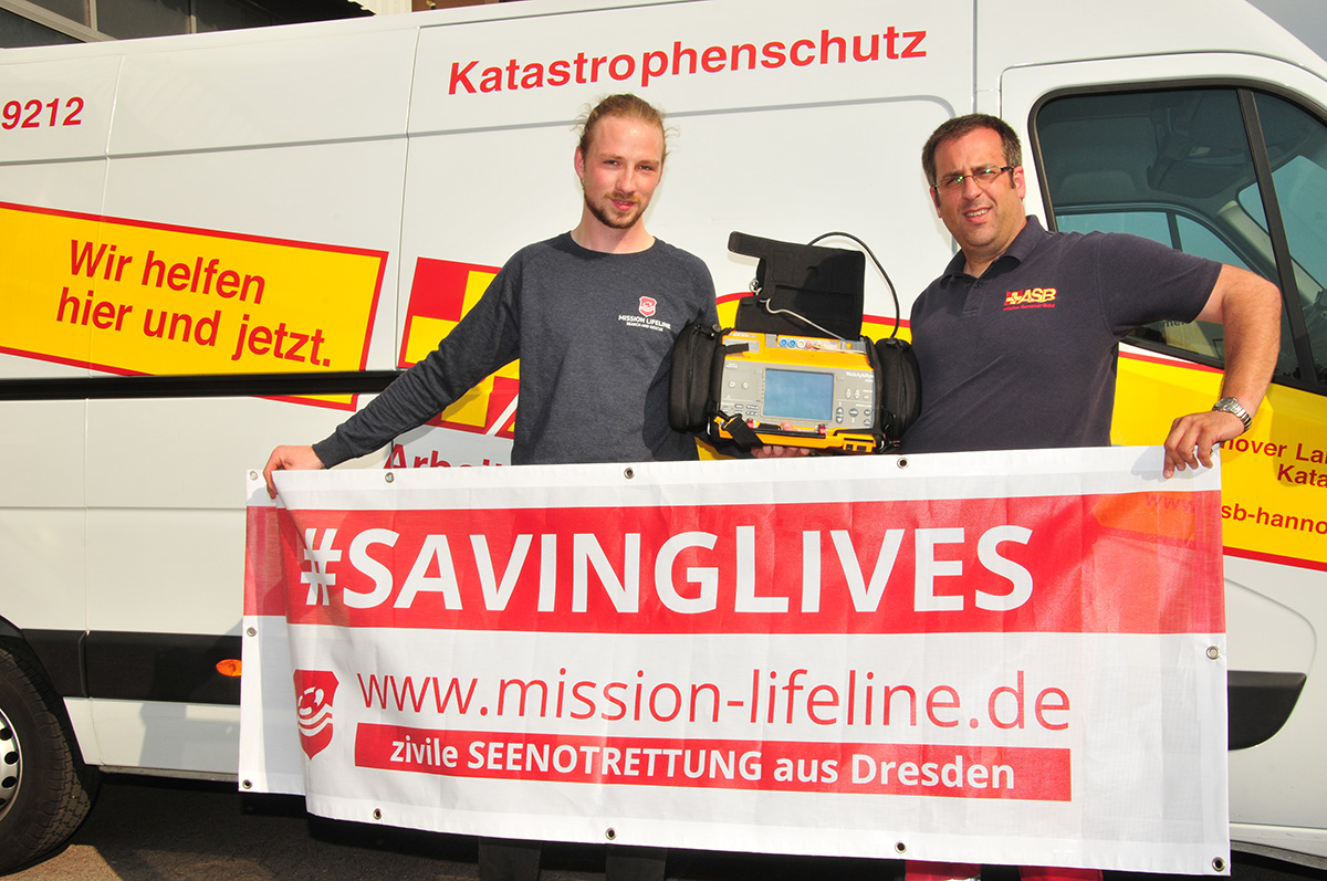 Übergabe Defibrillator Mission Lifeline: SEG-Zugführer Dirk Meinberg (rechts) übergibt ein tragbares Intensivrettungs-System an Leon van Bömmel von der Mission Lifeline 