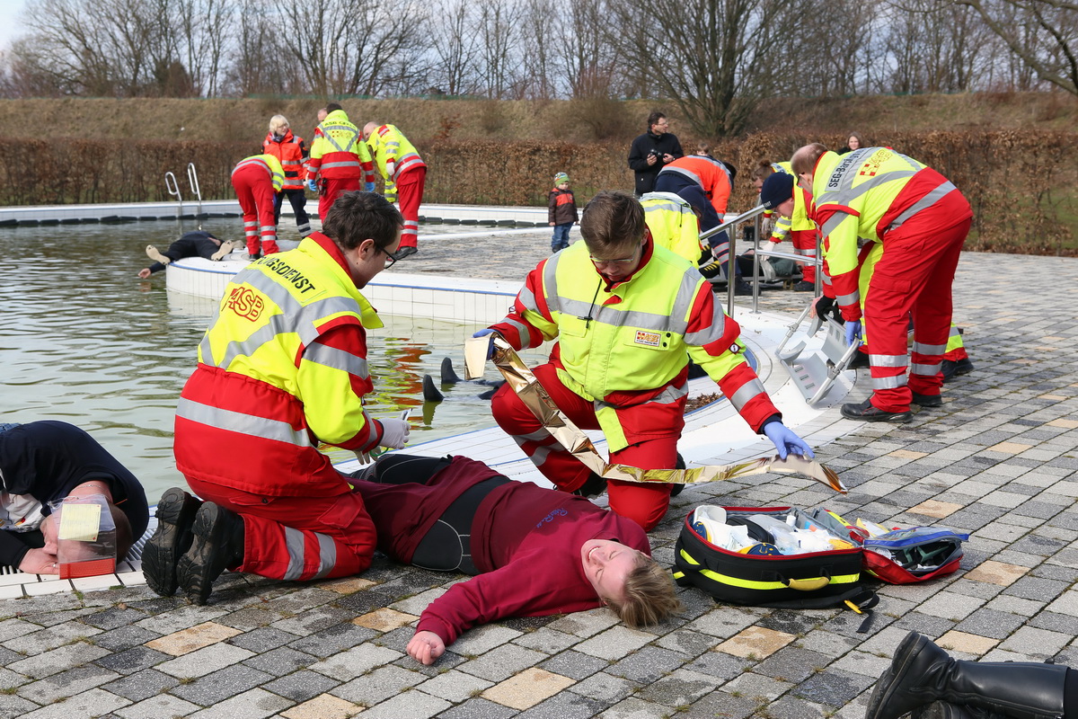 Mitglieder der Schnell-Einsatz-Gruppe kümmern sich an einem Badesee um Verletzte